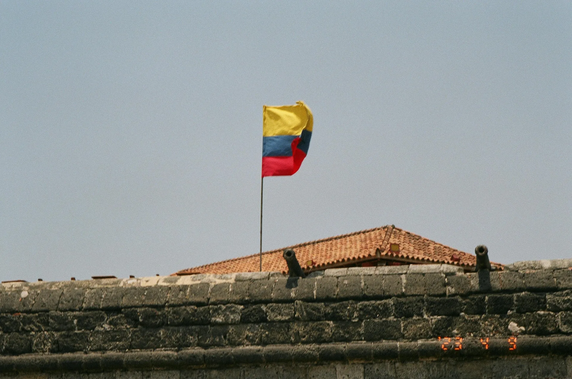 How to Apply for Colombian Citizenship (2026 Guide) — Colorful Colombian flag waving at a historic fort in sunny Cartagena, Colombia.