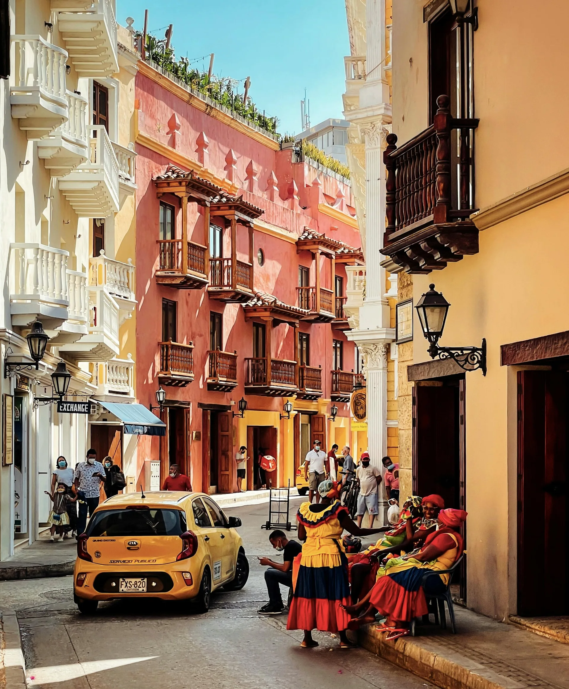 Study Spanish in Cartagena: A Practical 2026 Guide — Vibrant street in Cartagena with people in traditional dress, sunny atmosphere.