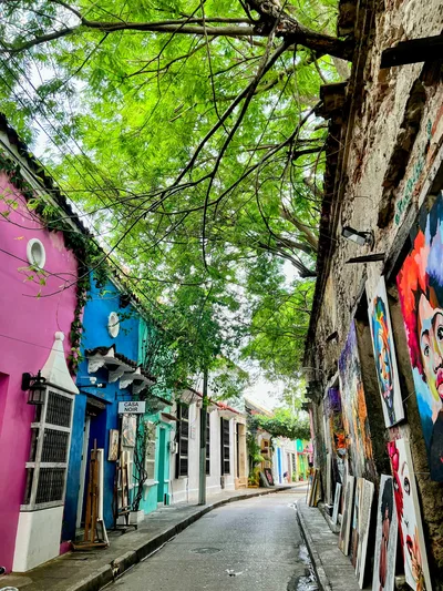 Explore a vibrant alley adorned with colorful murals and lively facades on a quiet day.