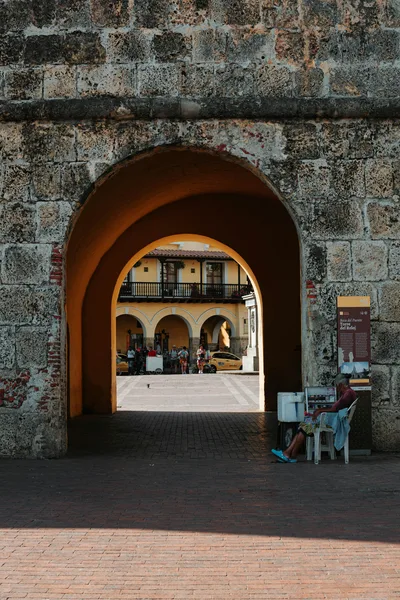 Historic colonial architecture in Cartagena, Colombia, framed by an archway under the sunny sky.