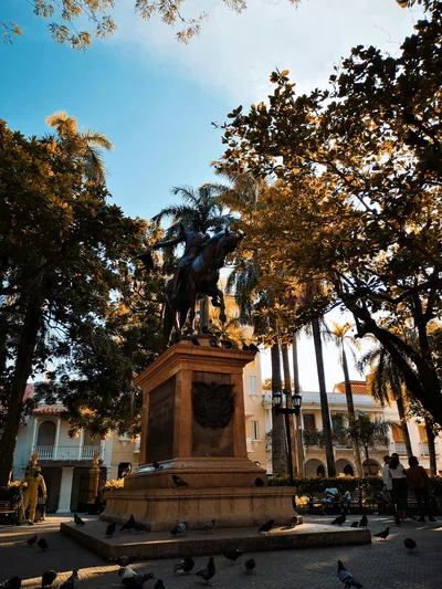 Equestrian statue in a plaza surrounded by trees in Cartagena, Colombia.