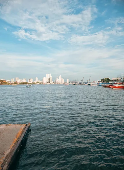 Panoramic view of Cartagena's cityscape across the lake with boats and buildings in the distance.
