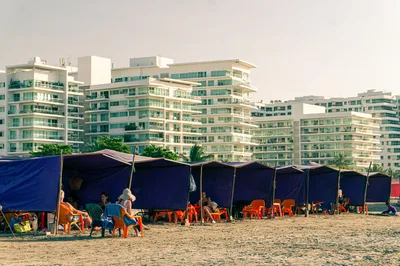 Relaxing beach scene with modern apartments in Cartagena, showcasing leisure and urban living.